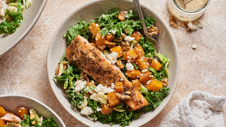 A bowl of salmon squash kale salad