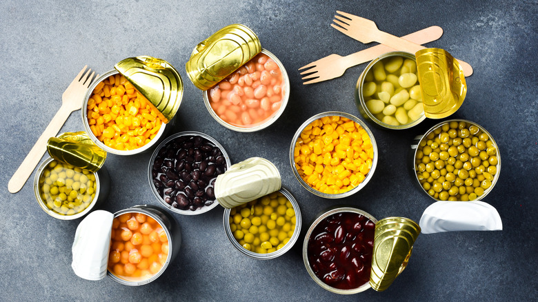 aerial photo of opened cans of beans on black countertop