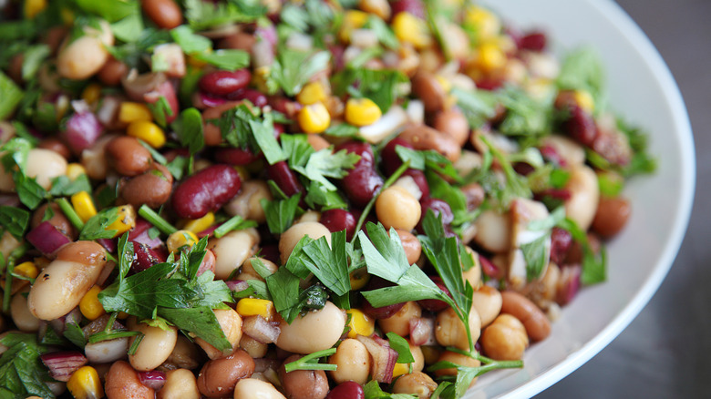 Close up of three bean salad with corn and herbs on a plate