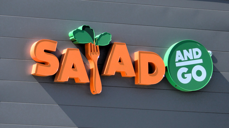 Orange and green Salad and Go sign on a building