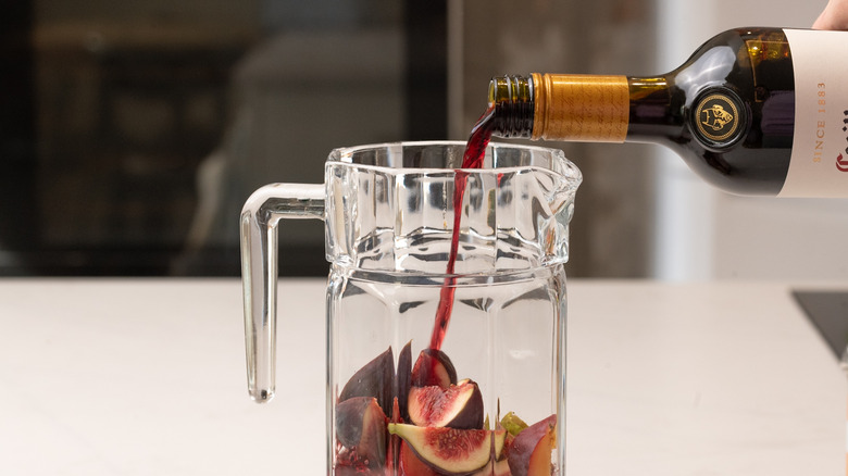 pouring red wine into pitcher