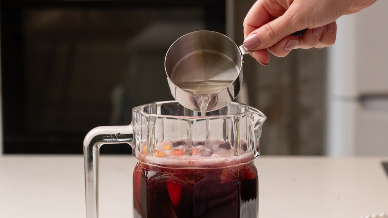pouring ginger beer into sangria
