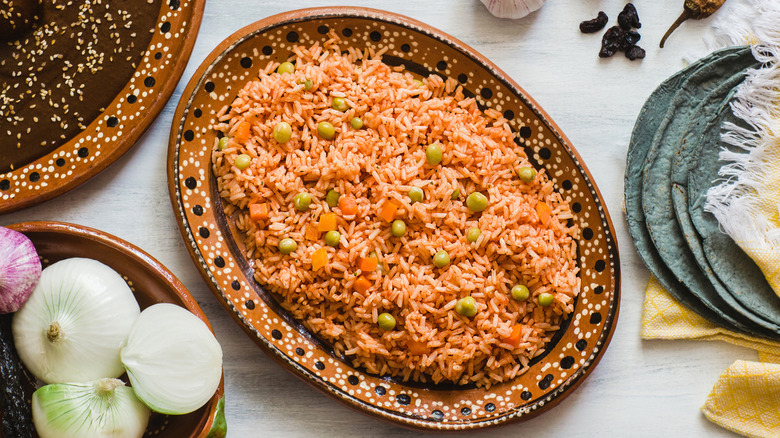 a platter of Mexican rice with tortillas and spices