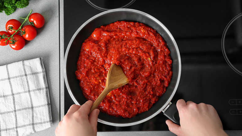 stirring marinara sauce with spoon