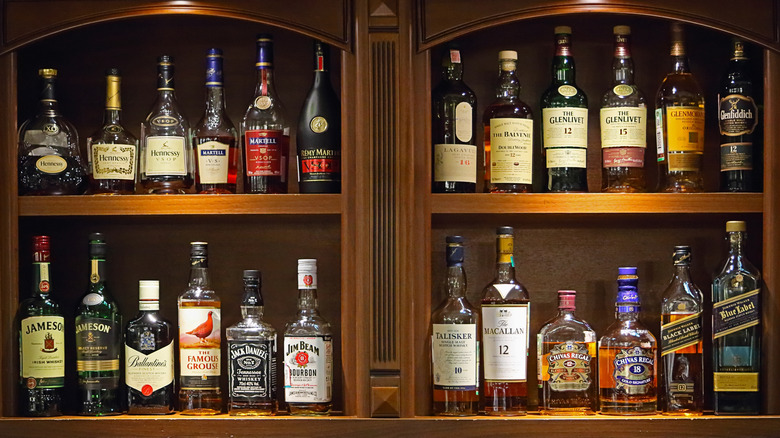bottles of whiskey on wooden shelving with the labels facing forward