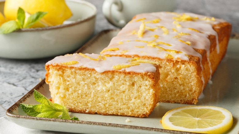 A lemon pound cake loaf is sliced on a plate.