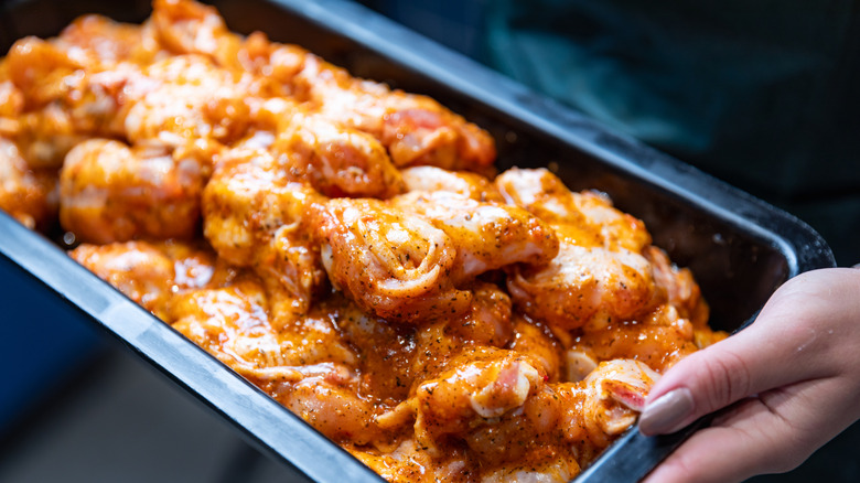 A tray of raw marinated chicken