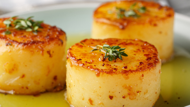 Golden fondant potatoes on plate