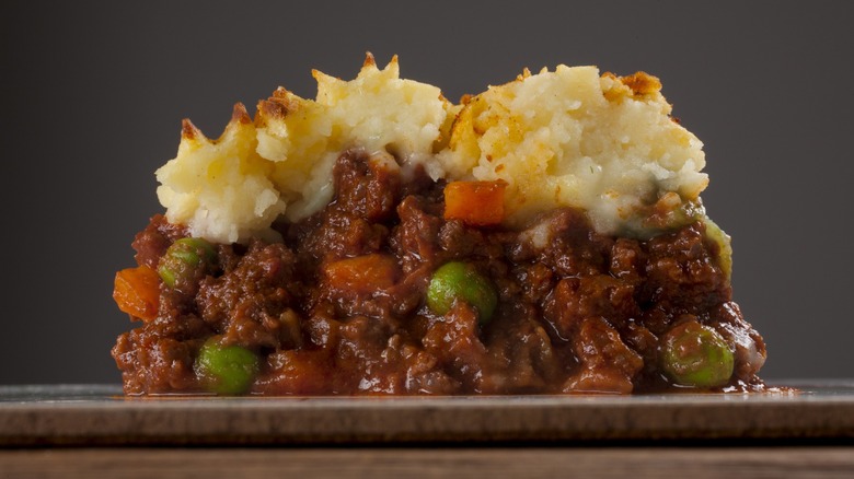 side view of shepherd's pie full of meat and veggies with browned potato on top
