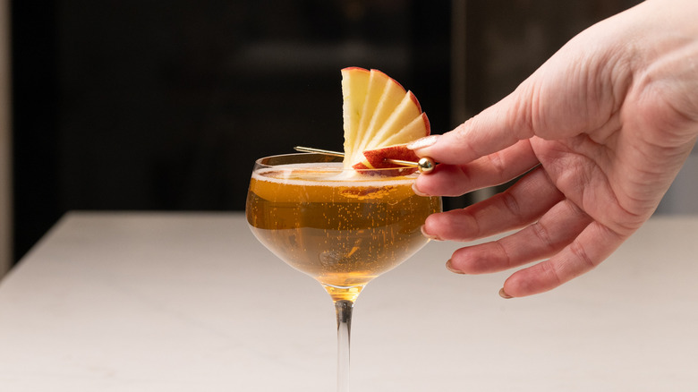 garnishing sparkling apple champagne cocktail