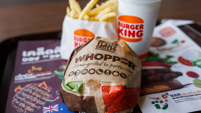 Burger king meal with Whopper in wrapper and drink and fries