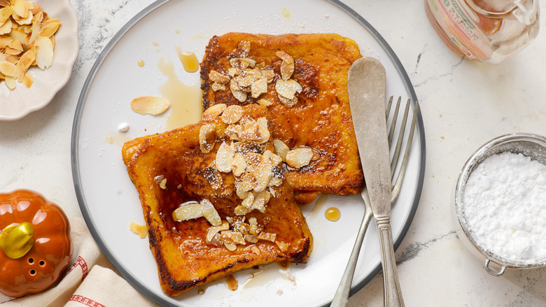 Overhead view of French toast on a plate with slivered almonds on top