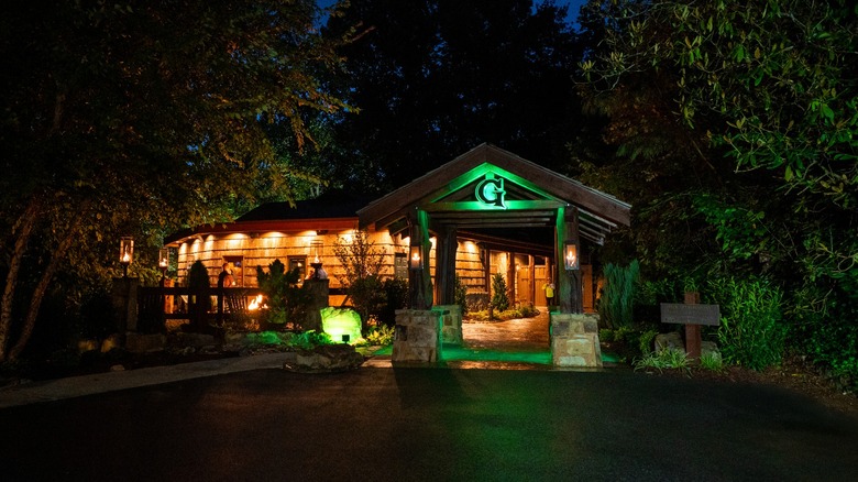 The outside entrance to The Greenbrier Restaurant lit up in green at night