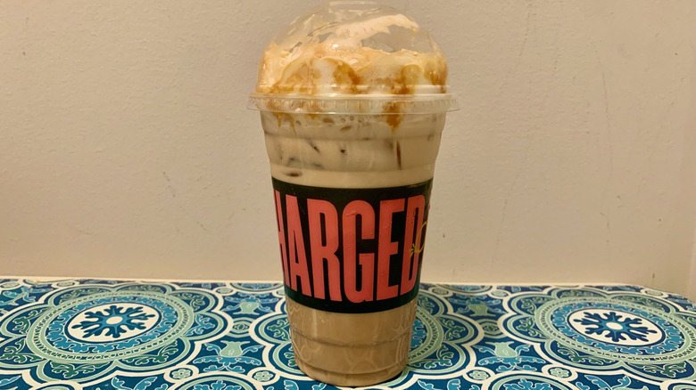 An iced caramel latte from Panera Bread topped with whipped cream on a table