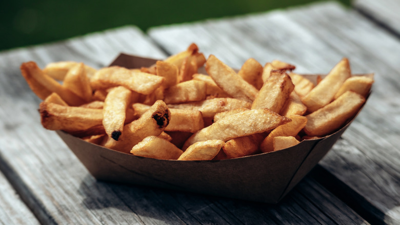 french fries in paper container on table