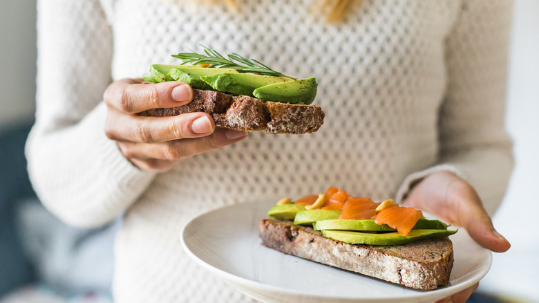 Person holding avocado toast slices
