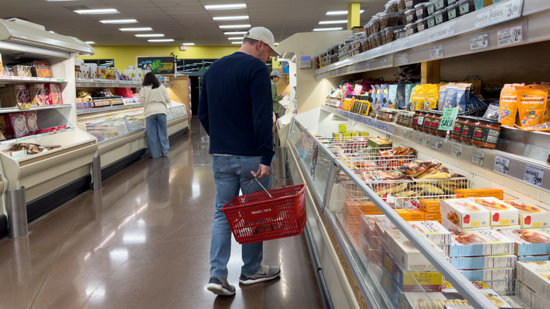 Male customer inside Trader Joe's grocery store shopping for frozen meals