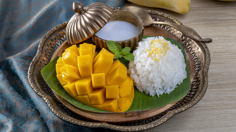 Mango alongside rice and a white liquid in a bowl