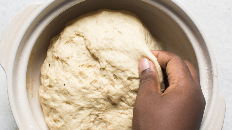 hand pinching bread dough