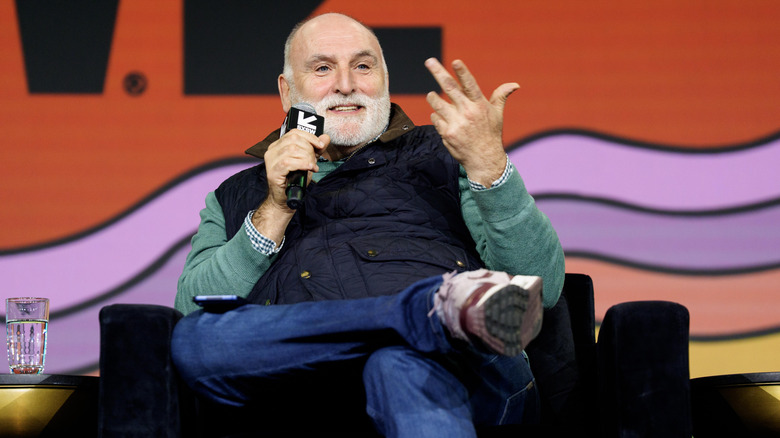 José Andrés, seated and holding a microphone, addresses the audience of a public event