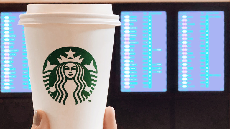 Starbucks cup against flight board