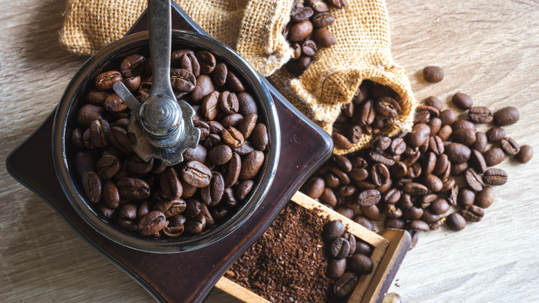 Overhead view of manual coffee grinder with beans