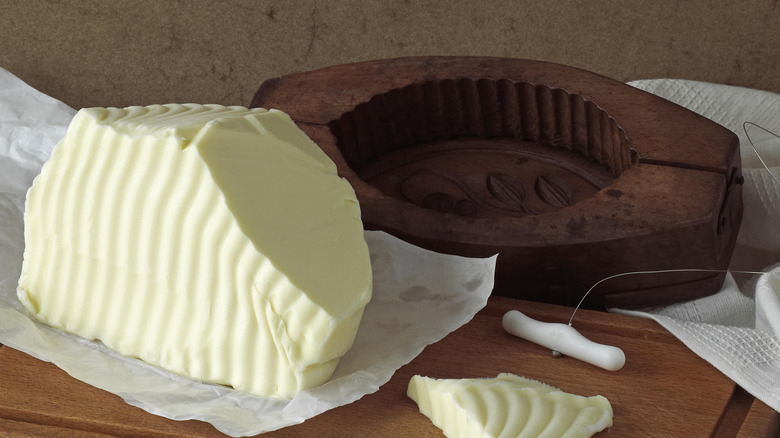 Wooden butter mold and fresh butter on a table