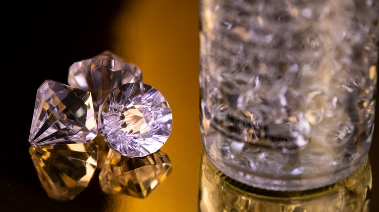 close up of diamonds next to bottle 