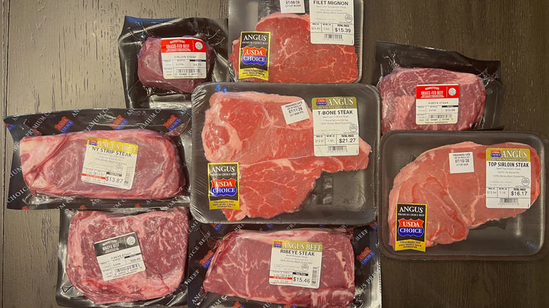 A pile of steaks bought from Walmart sit on a counter
