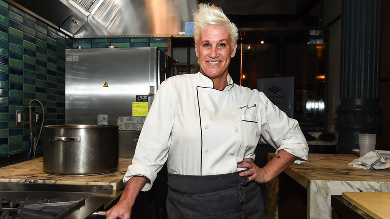 Anne Burrell in a chef's apron posing in a kitchen