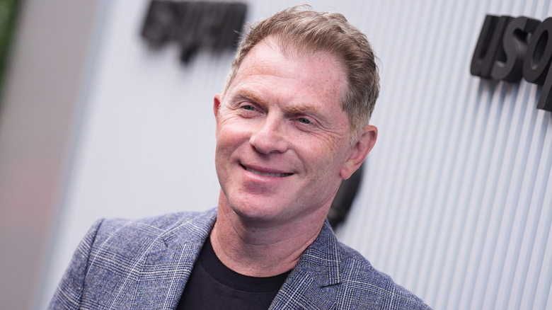 Bobby Flay at an event with a white background