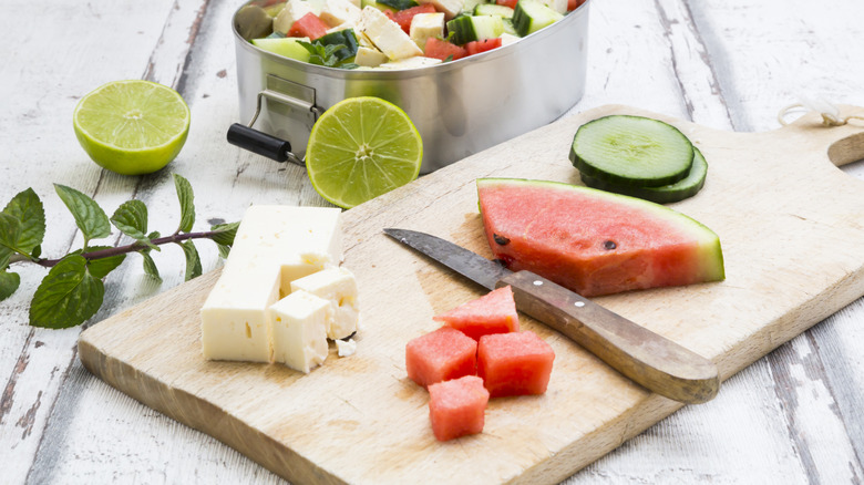 Watermelon, feta cheese, and cucumber on a chopping board