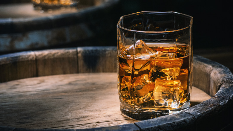 Glass of bourbon on cask