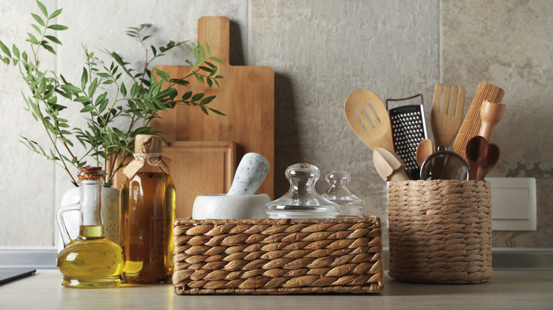 cutting boards, wicker baskets and oil bottles on a kitchen counter