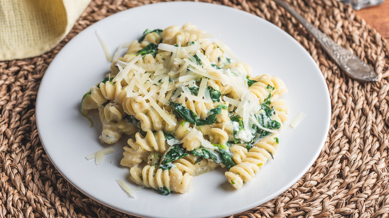 fusilli pasta with spinach, parmesan and cream sauce on a plate