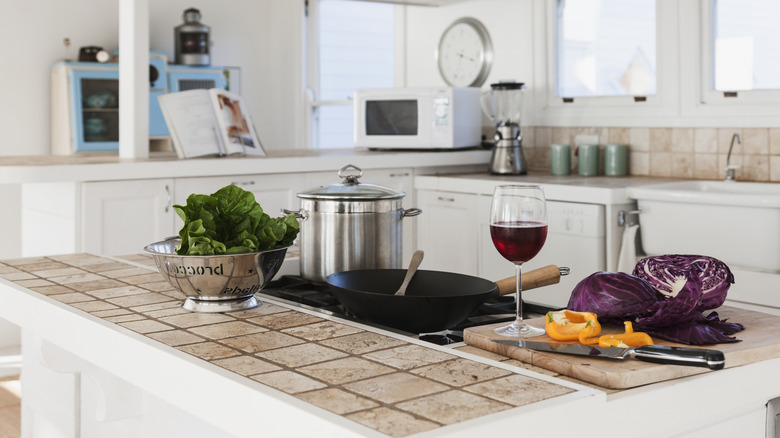 food on tiled kitchen countertop with glass of wine
