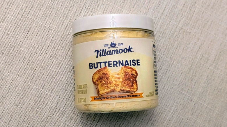 A close-up of a jar of Butternaise on a white tablecloth