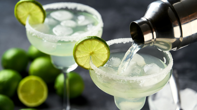 Two margaritas with lime garnishes