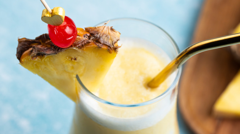 Piña colada garnished with pineapple wedge and a cherry
