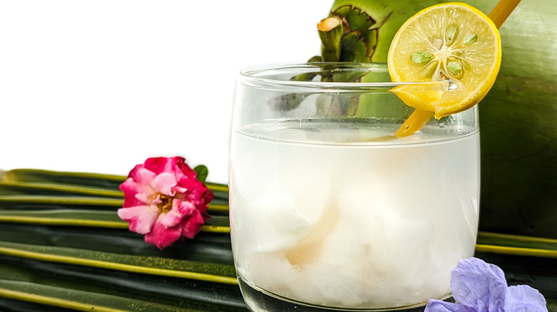 Glass of fresh coconut water with a lemon wedge garnish