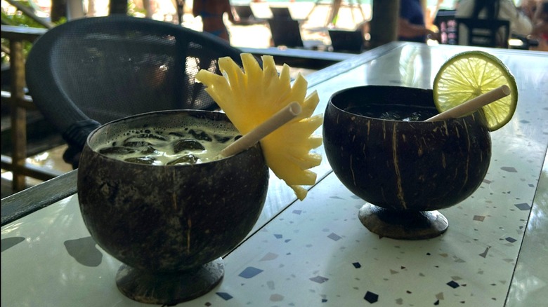 Two tropical drinks on an outdoor table