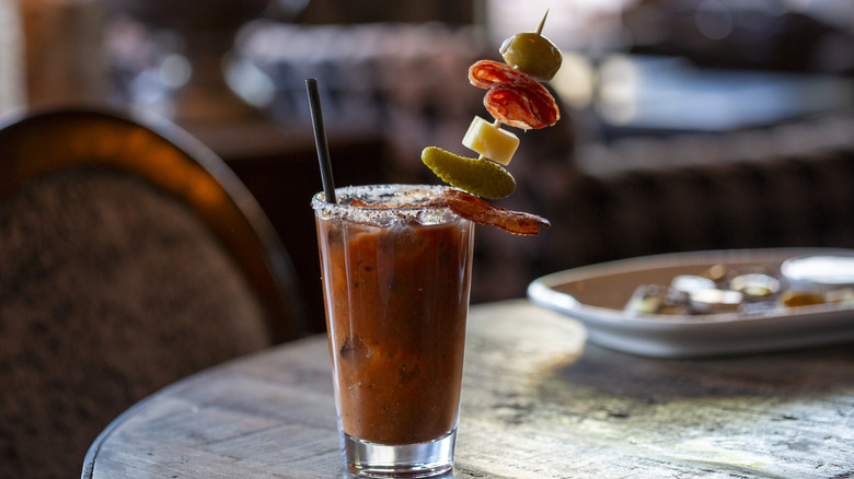 Bloody mary with a skewer of various garnishes
