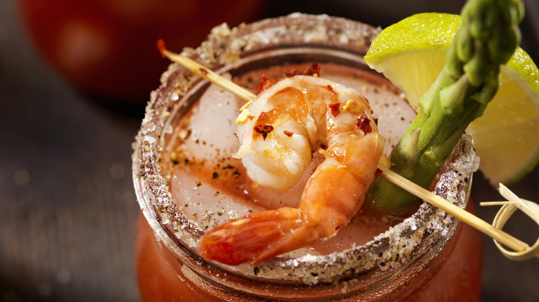 Bloody mary with a shrimp, asparagus spear, and lemon wedge on a salted rim
