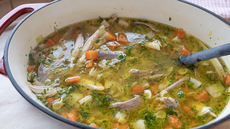 A cookware filled with chicken noodle soup