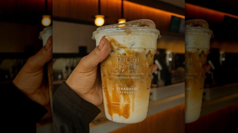 closeup of the top of a Starbucks iced caramel macchiato with cold foam