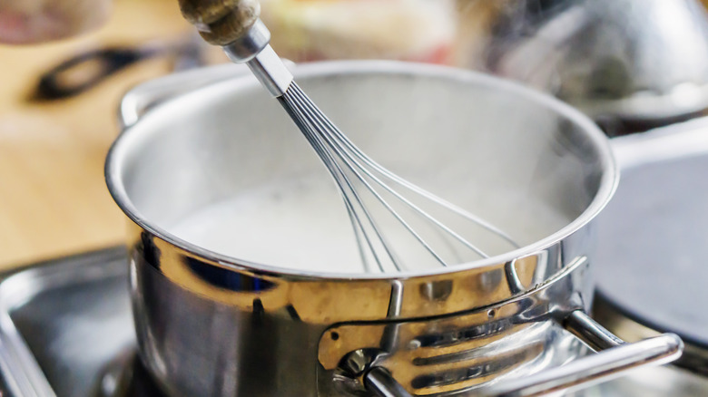 Steaming milk in pot with whisk