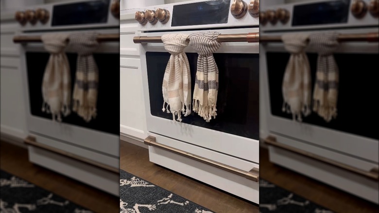 Two kitchen towels tied onto oven door handle