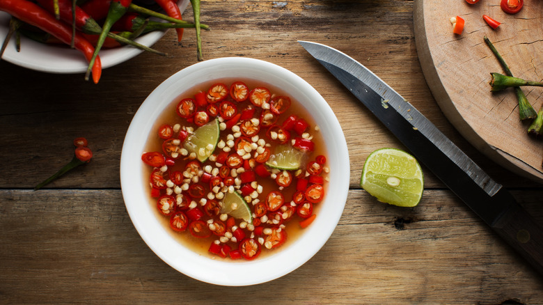 a bowl of Thai fish sauce with chiles and lime