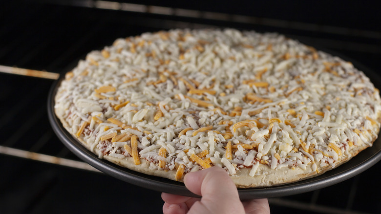 putting frozen cheese pizza in the oven