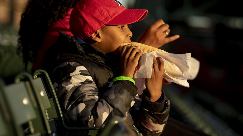 Baseball fan eating a hot dog